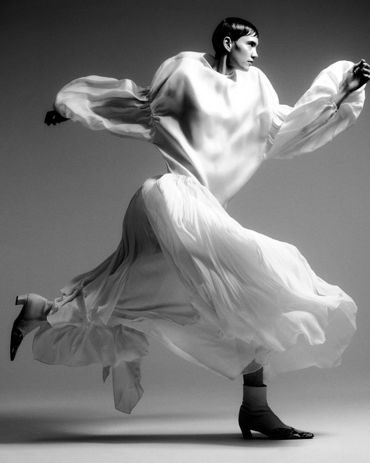 a woman in white is dancing with her legs spread out