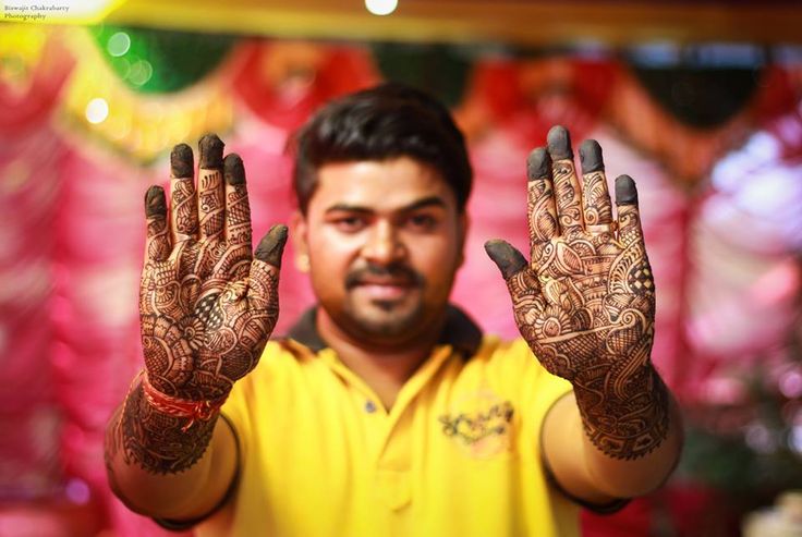 a man holding his hands up in front of him with hendi designs on it