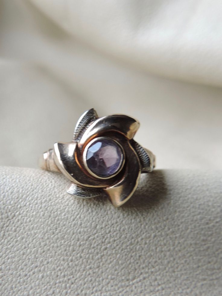 vintage gold ring - 10k gold amethyst ring - two tone gold ring - vintage 10k gemstone ring - so pretty - unusual vintage ring - hand crafted 3 dimensional ring - bezel set center amethyst - 3 yellow gold smooth pin wheels surround - 3 secondary white gold textured pin wheels - open back - pinwheels have volume and dimension - tapering band widens to meet a yellow gold whirl and a white gold whirl - stamped on interior of band - makers mark is MM inside a sideways arch - 10k - ring is a size 5 1 Antique Round Amethyst Jewelry, Vintage Purple Round Jewelry, Victorian Amethyst Round Jewelry, Purple Rose Cut Diamond Ring As A Gift, Antique Amethyst Jewelry Stamped 14k, Polished Vintage Amethyst Ring, 14k Gold Purple Jewelry For Anniversary, Vintage Purple Sapphire Gemstone Ring, Heirloom Style Amethyst Ring With Polished Finish