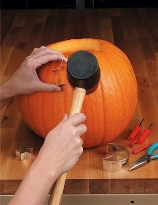 a person carving a pumpkin with a large knife