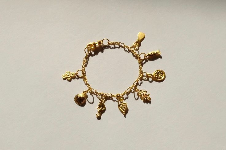 DETAILS: - A whimsical, vintage-esque collection of matte gold charms hang from matte gold peanut chain. - All metal components are 24k matte gold plated (thick, high-quality plating). The base metal is brass. The finish is hypoallergenic and free of lead, nickel, cadmium, and other irritating components. - This bracelet is adjustable up to ~ 8.25 inches in length.  - Handcrafted from start to finish.   NOTES: - Each Eleutheria piece is one of a kind. Some components on selected pieces are natur Bohemian Gold Charm Bracelet In Brass, Bohemian Gold Chain Bracelet With Lobster Clasp, Bohemian Gold Brass Charm Bracelet, Vintage Charm Brass Bracelet, Gold Brass Charm Bracelet With Vintage Charm, Gold Bohemian Charm Bracelet With Lobster Clasp, Bohemian Gold Charm Bracelet With Lobster Clasp, Chunky Gold Bracelet, Charm Bracelet Vintage