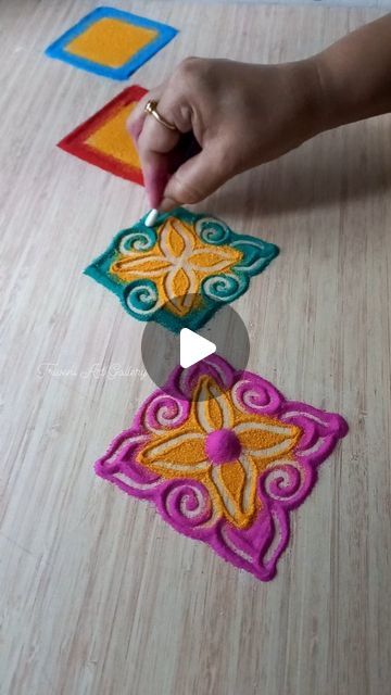 someone is doing something on the floor with their hand and fingers, while they are making decorative designs