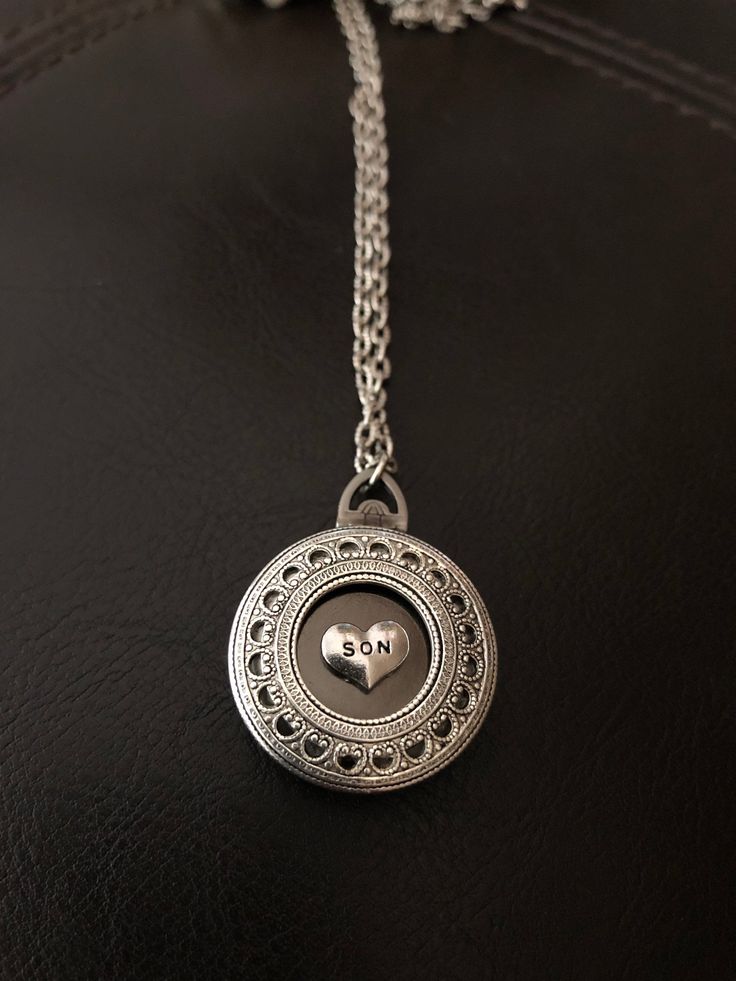 "🔸🔸orders are delayed by a few days this week. Thank you for your patience Son photo locket necklace, keepsake necklace This antiqued silver locket has been adorned with an antiqued silver SON charm which sets in a detailed antiqued silver bezel. This small folding spring locket is 1\" and can hold four small 3/4\" photos and hangs from 20\" of antiqued silver textured rhodium chain and lobster clasp. You can also purchase additional chain by the inch for a longer necklace during checkout. I c Memorial Medallion Locket Necklace For Mother's Day, Personalized Silver Locket Necklace For Mom, Silver Locket Necklace For Memorial On Mother's Day, Personalized Sterling Silver Locket Necklace For Mom, Silver Locket Necklace For Mother's Day Memorial, Engraved Sterling Silver Locket Necklace For Mom, Sterling Silver Locket Necklace Gift For Mom, Sterling Silver Locket Necklace For Mom, Nickel-free Medallion Locket Necklace For Memorials