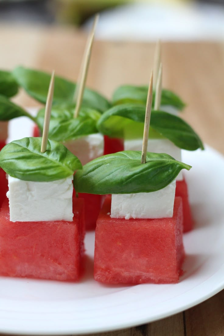 watermelon and basil skewers on a white plate