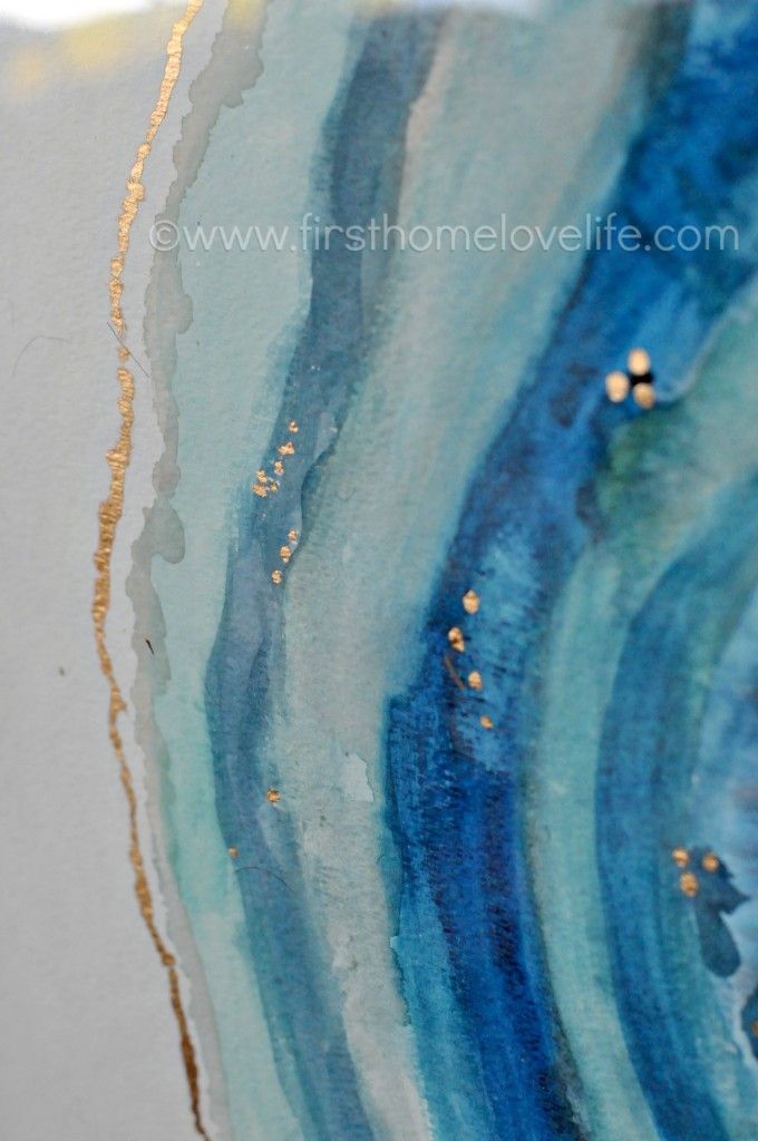 an abstract painting with blue and gold paint on the bottom half of it, as well as white background