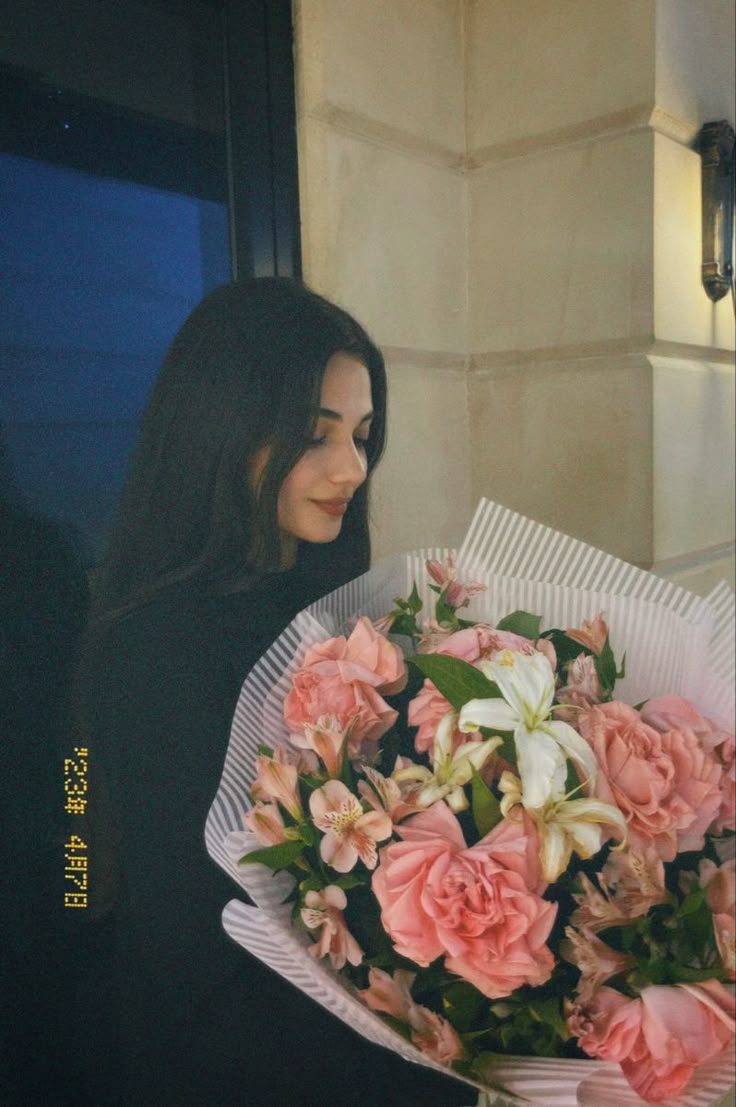 a woman holding a bouquet of pink and white flowers