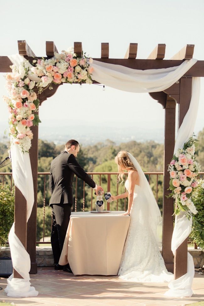 a bride and groom are getting ready to cut the cake at their outdoor wedding ceremony