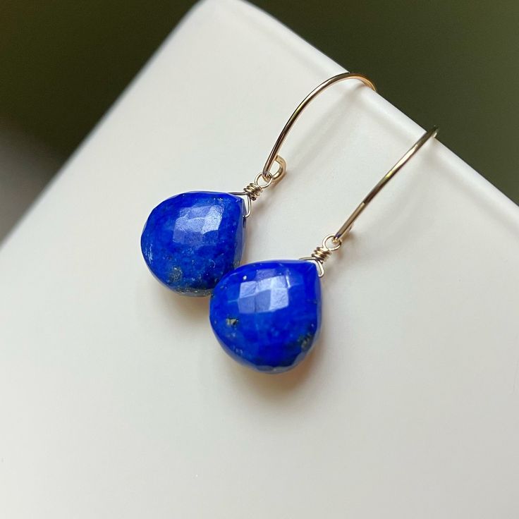 Microfaceted Lapis Lazuli briolettes sway from 14k yellow goldfilled earwires.   These gorgeous gemmy earrings are sure to punch up your wardrobe. Lapis measurements: 11mm Total length: 1 1/8 inch Please note that pictures of my jewelry are enlarged. The gemstone colors may vary on the device being used to view items. I do not alter the gemstone colors in my photos, but the backdrop can alter their look. My practice is always to add my jewelry last before heading out and to remove my jewelry fir Blue Teardrop Lapis Lazuli Earrings, Blue Lapis Lazuli Teardrop Earrings, Minimalist Blue Teardrop Jewelry, Nickel Free Blue Briolette Jewelry, Blue Briolette Teardrop Earrings For Gift, Blue Teardrop Jewelry For Everyday, Adjustable Gemstone Briolette Earrings, Sapphire Teardrop Gemstone Earrings, Handmade Teardrop Sapphire Earrings