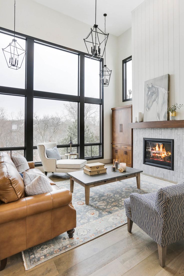 a living room filled with furniture and a fire place in front of a large window