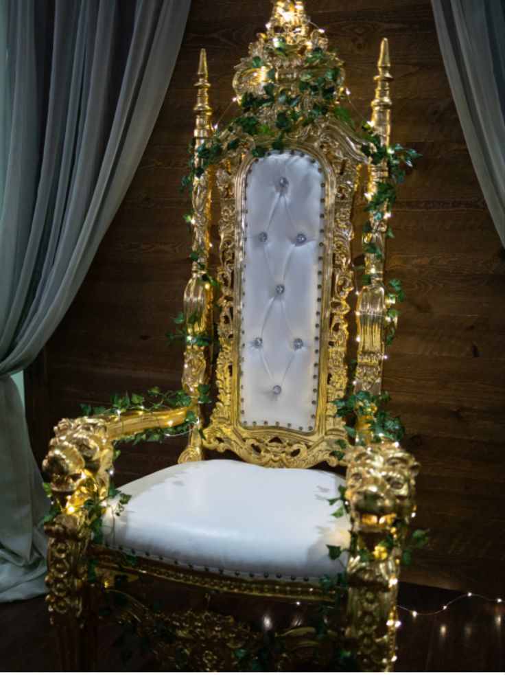 a gold and white chair decorated with greenery