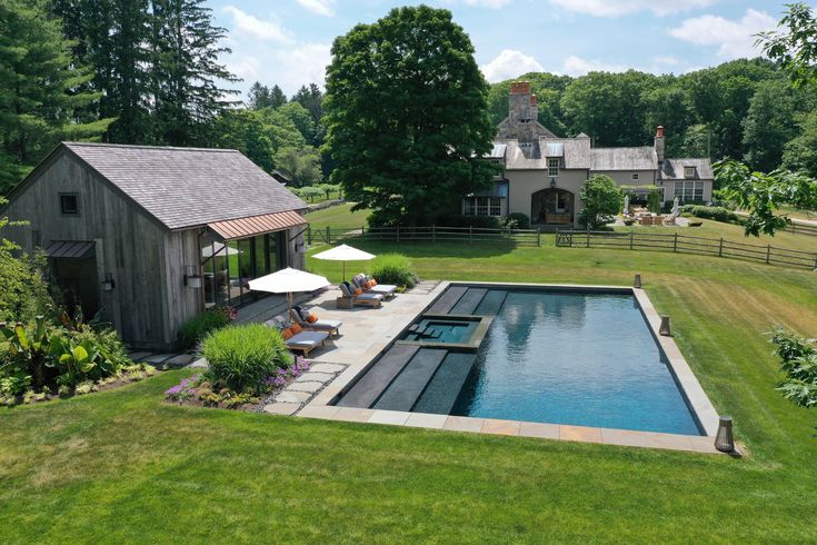 an outdoor swimming pool surrounded by lush green grass