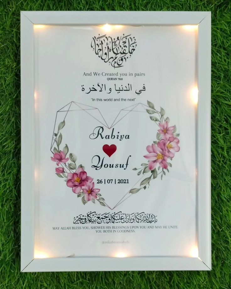 an illuminated frame with flowers and lights on the grass