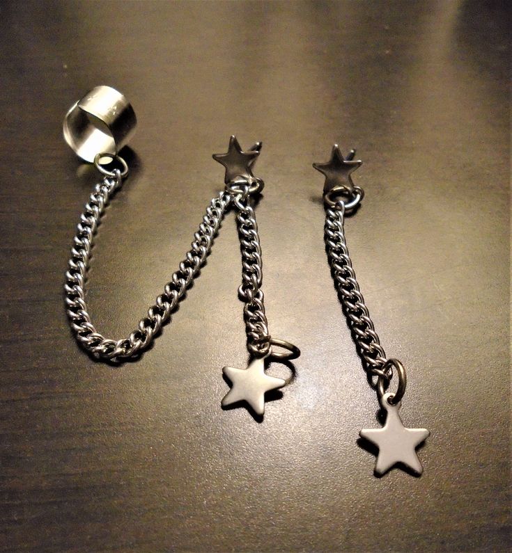 "Mismatched set Ear cuff with stars with long chain and star stud with star dangle.  Other is star stud with dangling star on chain. It is made on stainless steel and is hypoallergenic. This street style is totally lit! I only made a few sets so get 'em while you can! to see all my other items please go to www.etsy.com/shops/StudioJAndreL Thanks  :) Also you can follow me on instagram or facebook    Mark My Shop as in your \"favorites\" and be one of the first to see my newest items in your Etsy Updates!" Star Piercing Jewelry, Cute Star Earrings, Metal Dangle Ear Cuff Single Earring, Metal Dangle Ear Cuff, Metal Dangle Ear Cuff With Adjustable Chain, Trendy Metal Ear Cuff For Pierced Ears, Edgy Silver Star-shaped Jewelry, Trendy Metal Ear Cuff With Matching Earrings, Trendy Star-shaped Chain Jewelry