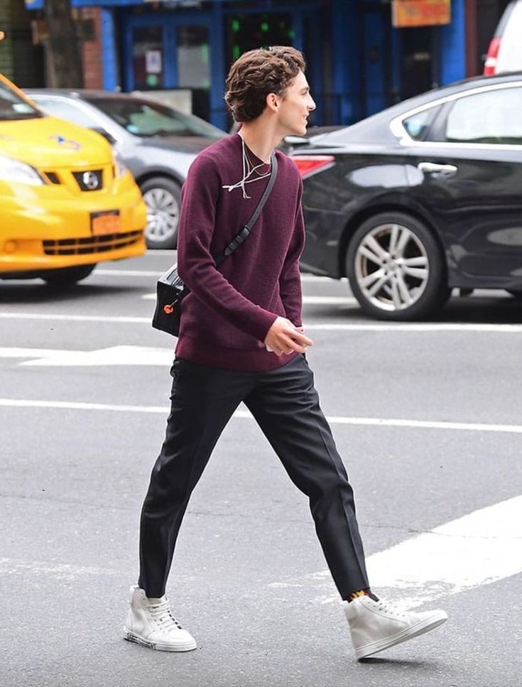 a man walking across the street wearing headphones