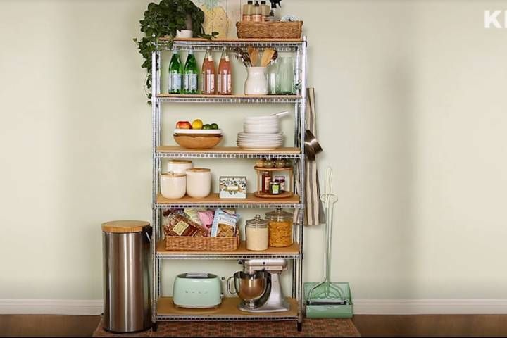 a metal shelving unit filled with lots of food and drinks on top of a hard wood floor