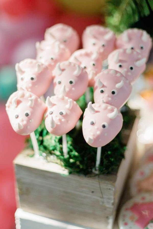 there are many pink candies on the stick in the box that is decorated like bears