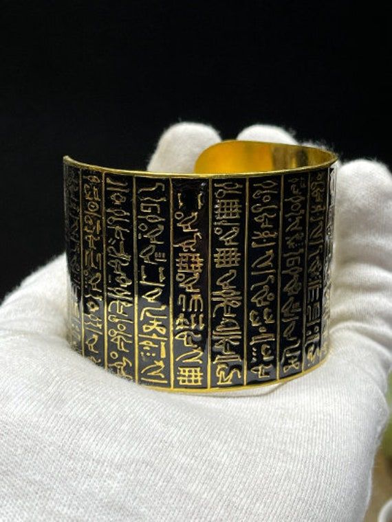 Egyptian bracelet made in Egypt. Premium quality. Handmade from Brass with amazing Gold 18k karat, Specially made for you ;) A very unique piece you will never find it anywhere ;) Note: You can use this bracelet whatever the size of your hand because it is a free size bracelet Symbolic Gold Bangle Bracelet, Spiritual Gold Bangle Bracelet As Gift, Gold Etched Bracelet, Handmade Symbolic Bangle Bracelets, Gold Spiritual Cuff Bracelet As Gift, Handmade Gold Bracelets For Gifts, Collectible Gold Jewelry With Unique Design, Etched Metal Bangle As Gift, Unique Gold Engraved Cuff Bracelet