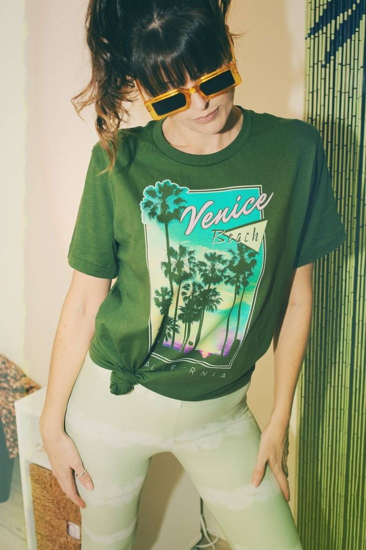 venice beach graphic tee 80s graphic t shirt vintage style shirt eighties shirt 80s beach tee california t shirt retro venice beach tee Size Guide: Our 100% cotton Venice Beach tee comes in a Unisex style on Green. Please refer to the provided tee measurements given in the listing images. It is advisable to compare these with the measurements of your favorite tee when making your size selection. Please note our tees are not women's fitted.     Details: ☆ Unisex style ☆ 100% cotton ☆ Crew neck ☆ Summer Graphic Print T-shirt For Streetwear, Summer Streetwear Tops With Screen Print, Summer Streetwear Graphic Print T-shirt, Green 90s Style T-shirt For Summer, Retro Summer T-shirt With Front Print, Summer Graphic Design Crew Neck T-shirt, Vsco Style Letter Print T-shirt For Streetwear, Summer Tops With Graphic Design In Relaxed Fit, Relaxed Fit Summer Tops With Graphic Design