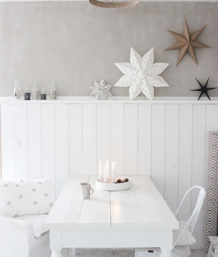 a white table and chairs in a room with star decorations on the wall behind it