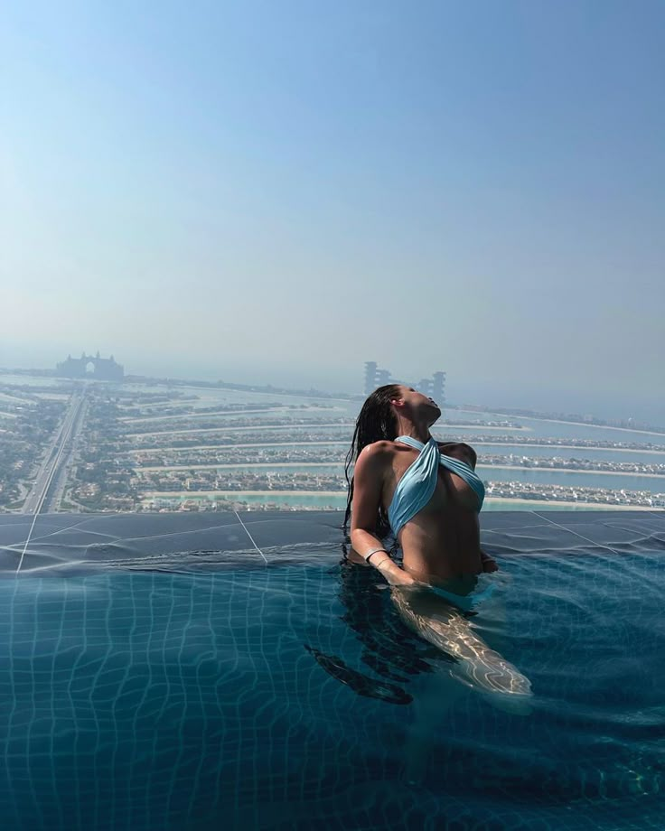 a woman sitting on top of a swimming pool