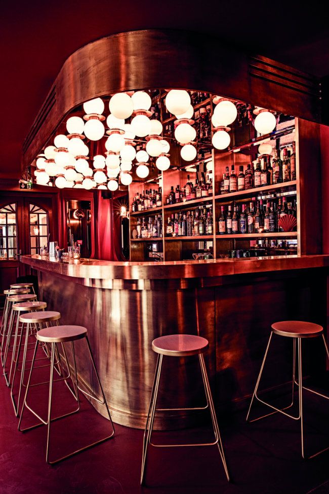 a bar with stools and lights hanging from the ceiling