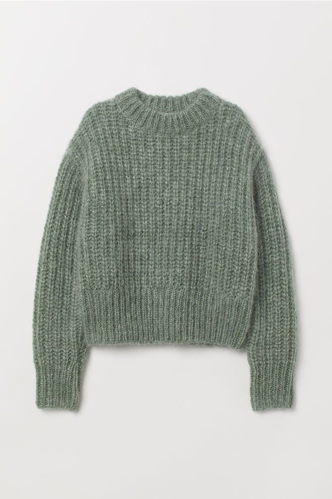 the green sweater is made from wool and has a ribbing pattern on the shoulders