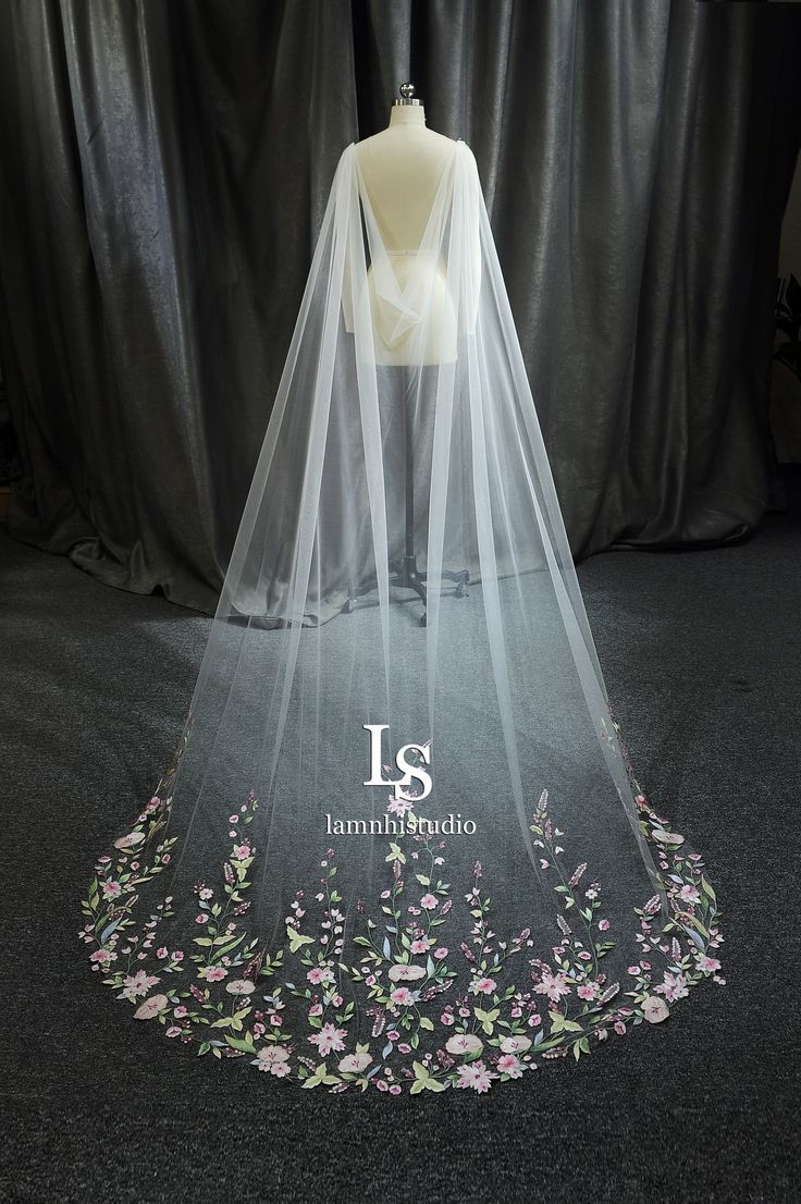 a wedding veil with pink flowers on it and the number 13 printed in white letters