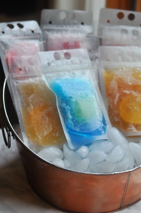 four bags of soap sitting on top of ice in a metal container with water and gummy