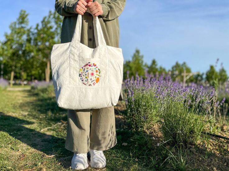 -Ready to ship- This is hand embroidered summer chic and elegant tote bag. My friend Greenhoopembroidery  https://www.etsy.com/listing/1749089657/hand-embroidered-summer-tote-bag?click_key=0852581f4194af351cb51973148ecf6436dcfd41%3A1749089657&click_sum=045257c3&ref=shop_home_active_2&pro=1&frs=1 sew the tote bag and embroidered flowers on it. For customized designs for tote bag you can send a message to her shop! * White fresh summer tote bag. * It has a cotton lining inside it. * Has multiple p White Hobo Bag, Multi Pocket Bag, Summer Tote Bag, Embroidered Shoulder Bag, Summer Tote Bags, Embroidered Tote Bag, Embroidered Tote, Summer Tote, Chic Flowers