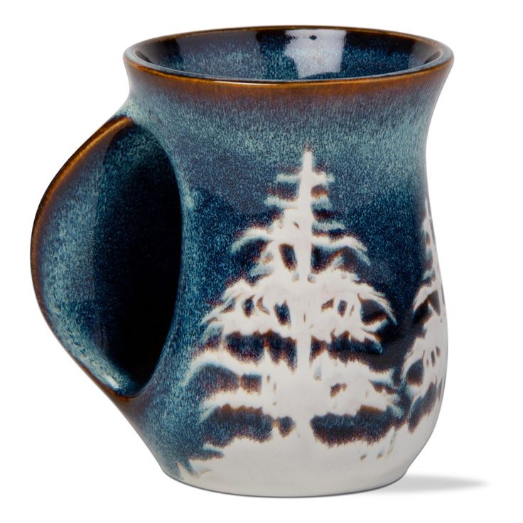 a blue and white mug with trees on it