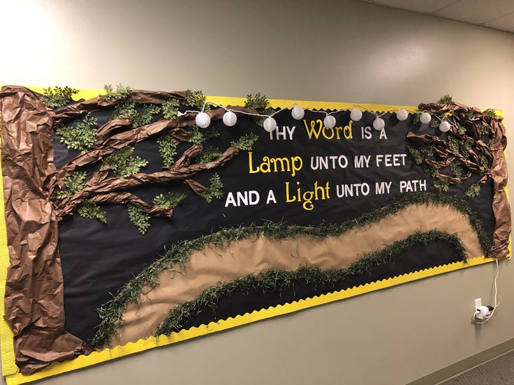 a bulletin board with words written on it in an office hallway, decorated with trees and branches