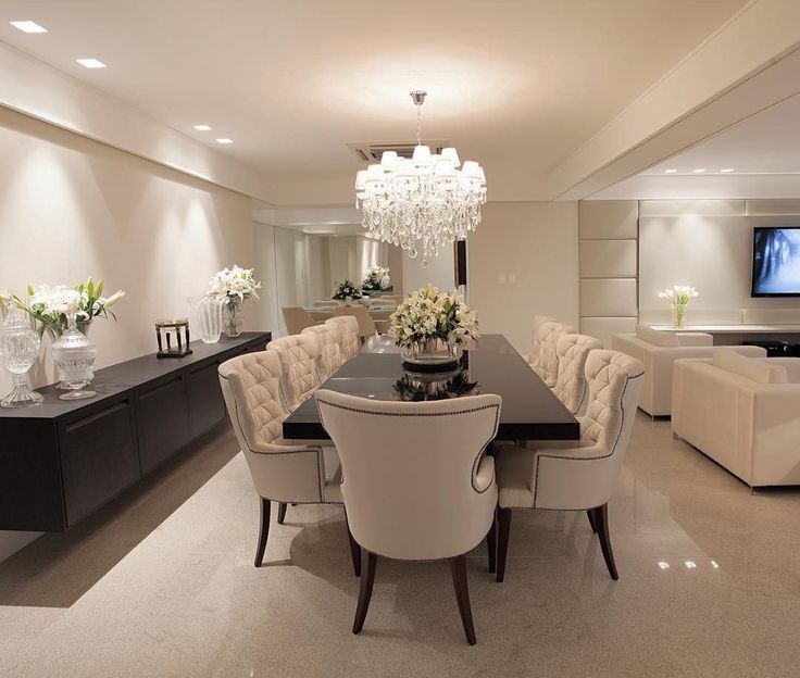 an elegant dining room with chandelier and white chairs in front of the table