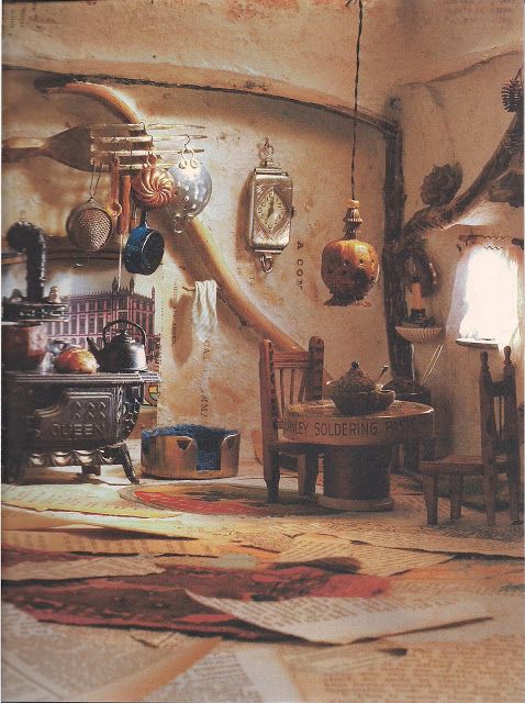 an old fashioned kitchen with pots and pans hanging on the wall