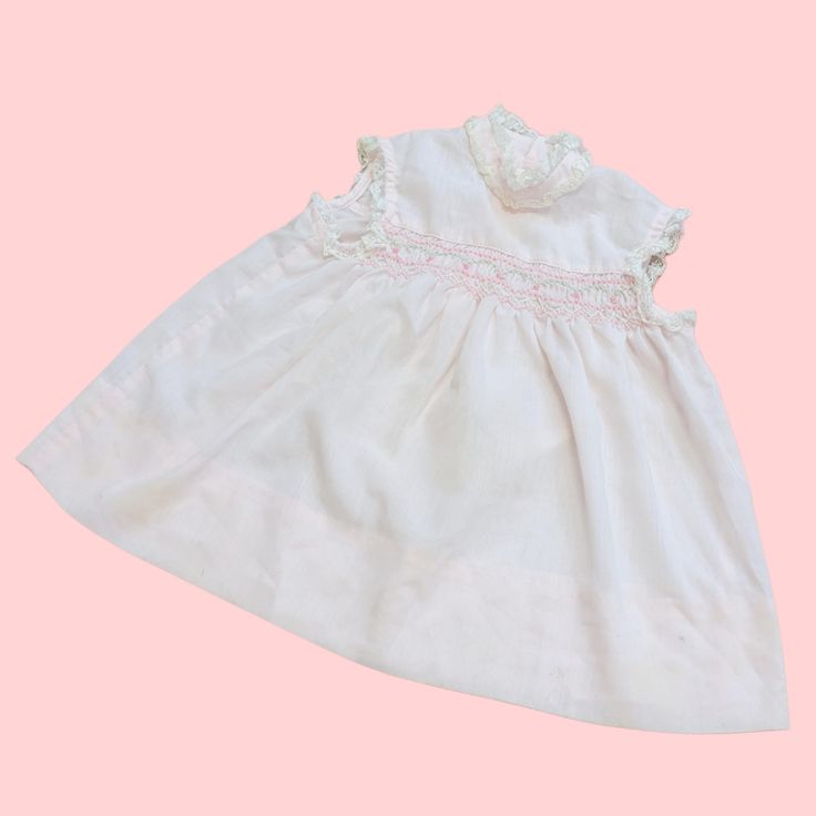 Vintage 60s Baby Dress! Pastel Pink babydoll with Floral Embroidered detail! Sleeveless with the cutest lace collar and trim. Marked a size T2, Polly Flinders, Hand Smocked! has staining throughout the skirt Chest: 23" Waist: 35" Hips: 39 1/2" Length: 15 1/2" 1.7 oz. Sleeveless Lace Dress With Smocked Back, Fitted Vintage Smocked Dress For Summer, Vintage Cotton Smocked Dress With Smocked Back, Spring Vintage Smocked Dress, Vintage Cotton Dress With Smocked Back, Sleeveless Smocked Dress With Lace Trim For Spring, Vintage Smock Dress For Daywear, Cute Fitted Sleeveless Smocked Dress, Vintage Smocked Ruffle Dress For Summer