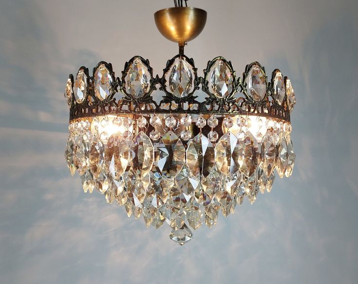 a chandelier hanging from the ceiling with lots of crystal drops on it's sides