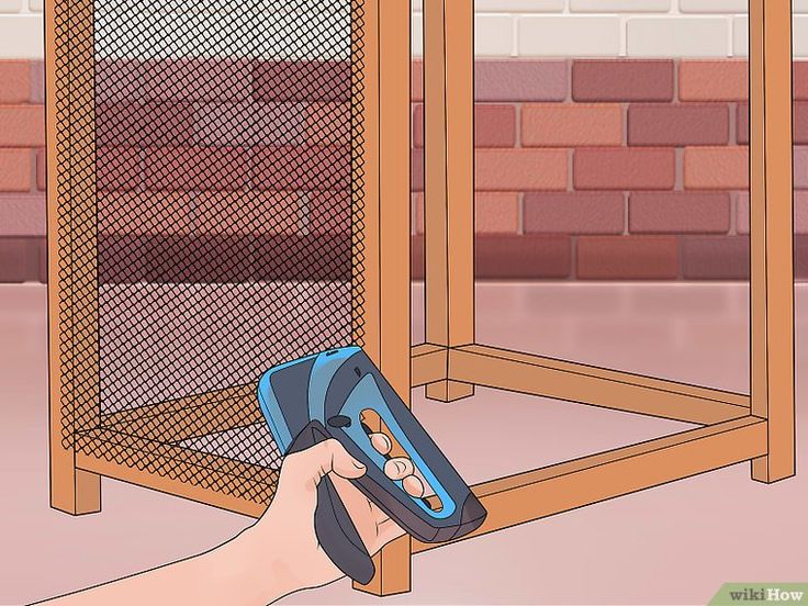 a hand holding a remote control in front of a cage