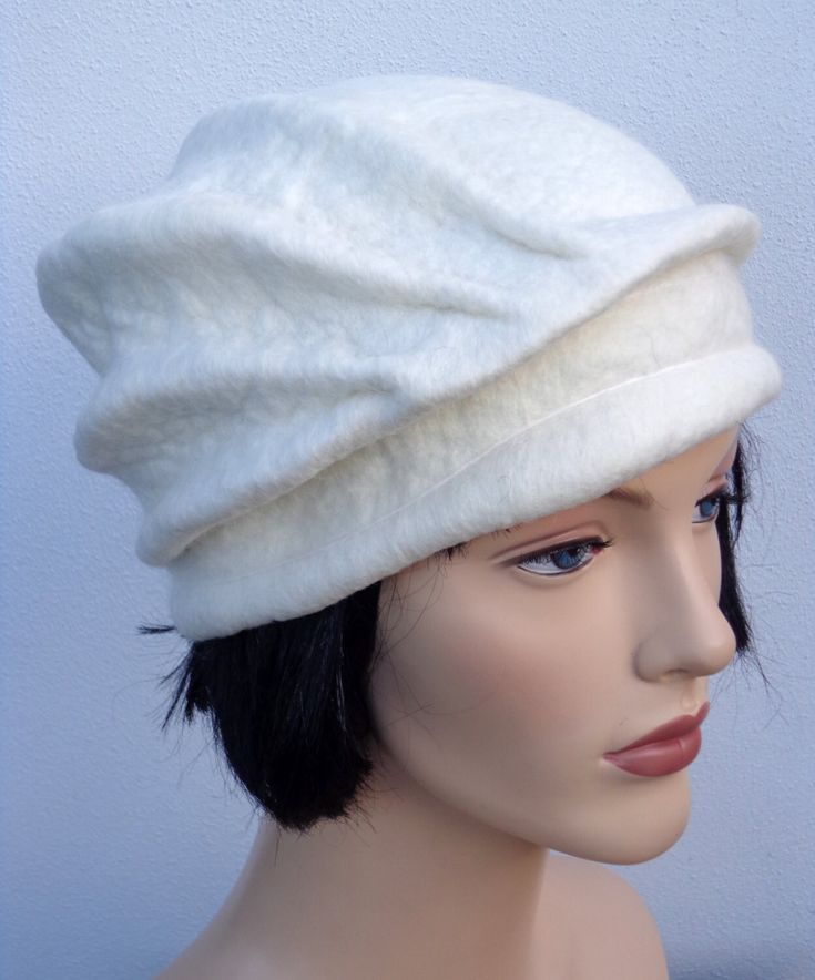 This is a cute beret made of white merino wool. This beret has been felted by hand. The shape is asymetrical and stylish. Because it is soft and comfortable, it is a great hat for winter and also for falls and spring. It can be positioned in different ways, by bringing more or less the folds on the front side.  ** Turnaround time ** It will take 3-5 days to re-create a model similar to this one. Rush order? Other colours? Contact the shop! DO NOT FORGET TO INDICATE YOUR HEADSIZE (please follow t Elegant Beanie Hat One Size, Elegant Handmade Winter Hats, Handmade Fitted White Hat, Elegant White Felt Hat For Winter, White Fitted Felt Hat, Elegant Winter Cloche Hat, White Short Brim Felt Hat For Winter, White Cloche Hat With Short Brim For Winter, Elegant Fitted Beanie Hat