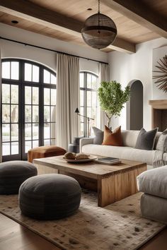 a living room filled with lots of furniture next to large windows and a fire place