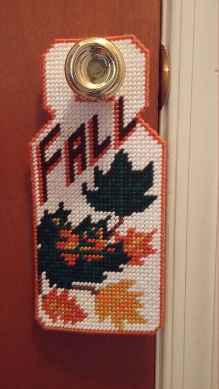 a cross stitch door hanger with the word fall on it