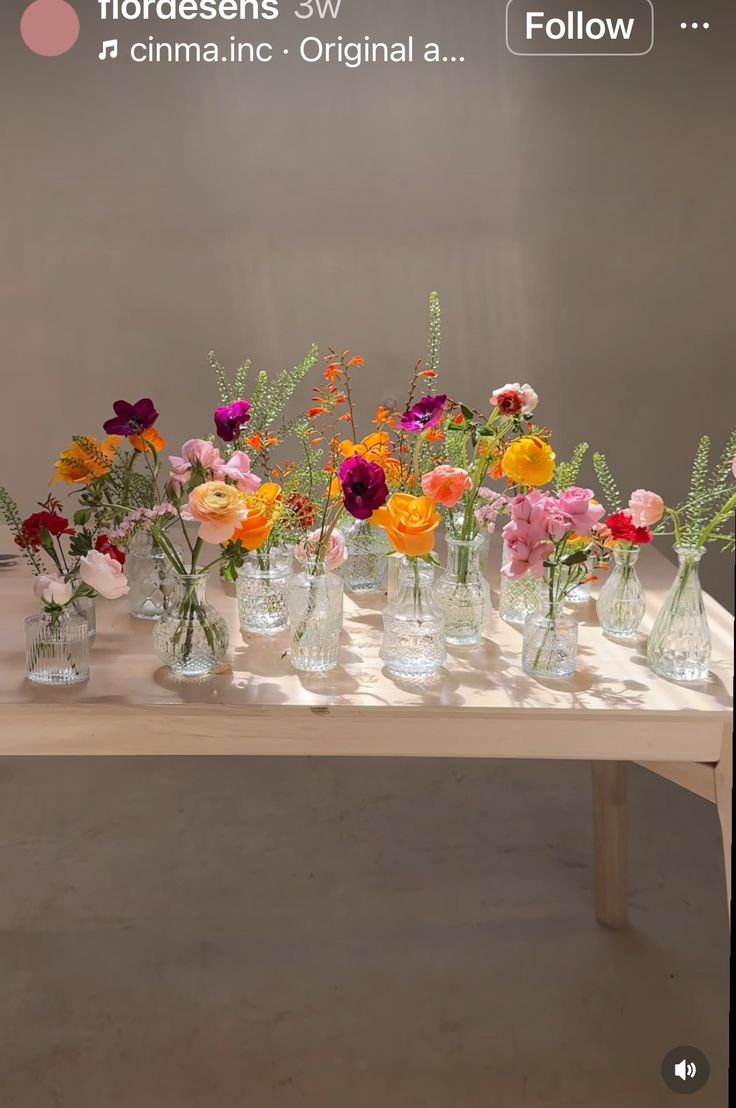 there are many vases with flowers in them on the table and one is empty