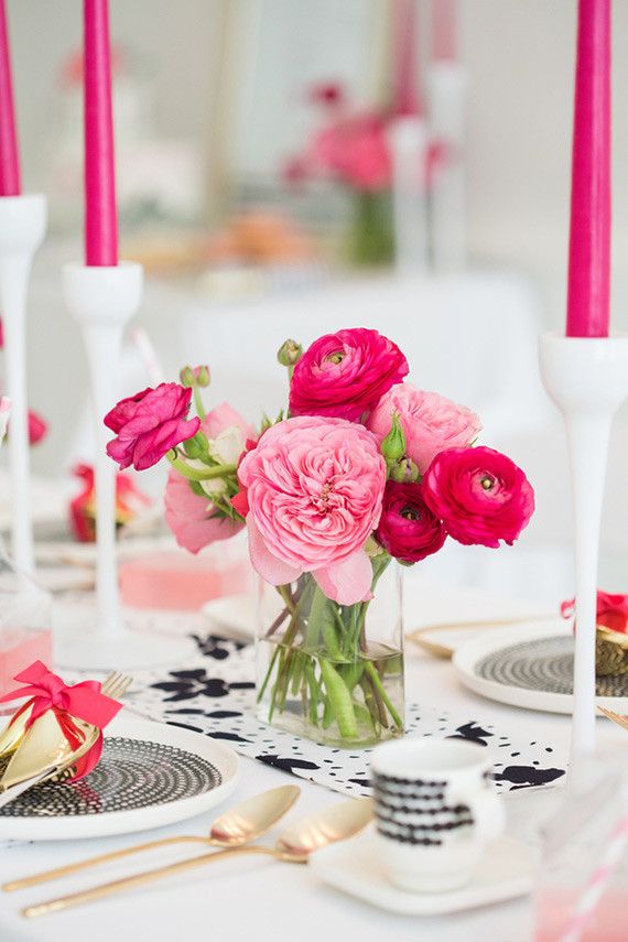 a table with pink flowers and candles on it