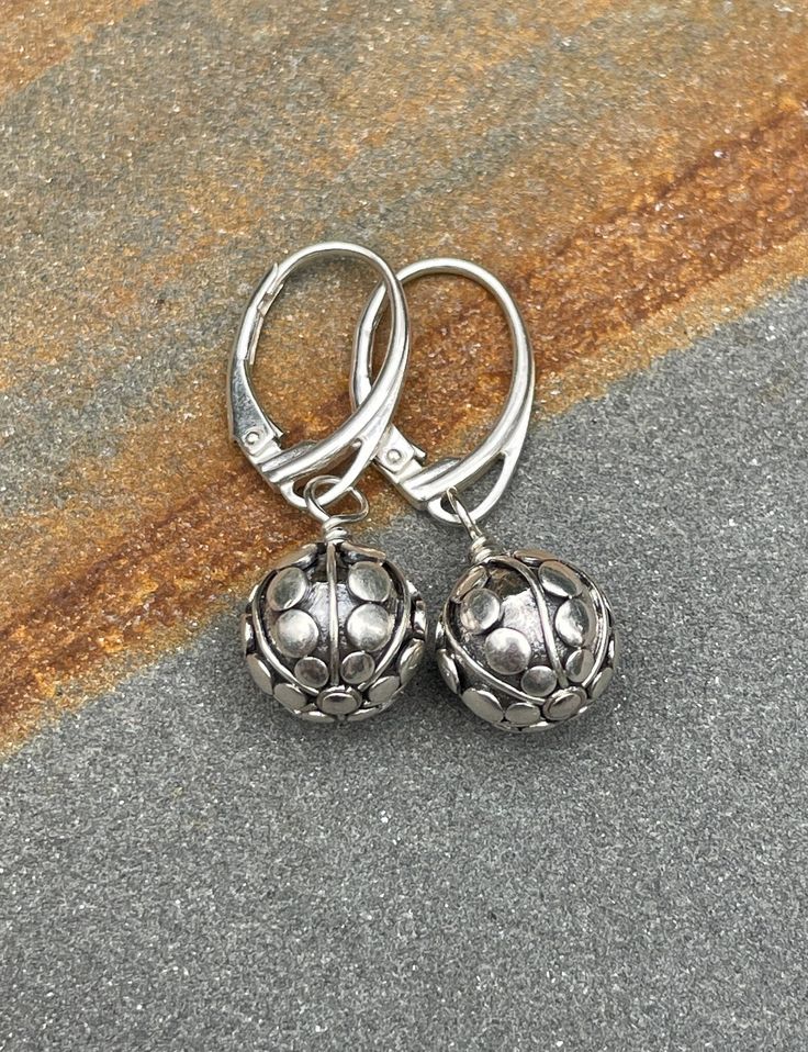 Sterling silver leverback Earrings. The Bali sterling silver earrings are handmade. The beads have a pattern of lines and dots they are 10 mm wide. The earrings are 1 3/16 inches (3.0 cm) in length. Choose earring wires from the drop-down menu. The pictures are enlarged to show detail. The earrings ship in a small organza bag inside a gift box, ready to give... or keep! To see more WireAndPearl sterling silver earrings, please visit: https://www.etsy.com/shop/WireAndPearl?section_id=18630564 Als Silver Lever Back Jewelry Gift, Silver Lever Back Jewelry As Gift, Silver Lever Back Jewelry For Gift, Dainty Silver Earrings With Round Beads, Adjustable Silver Jewelry With Lever Back, Silver Drop Earrings With Lever Back, Silver Round Earrings With Lever Back, Silver Earrings With Lever Back Ear Wires For Gifts, Silver Round Lever Back Earrings