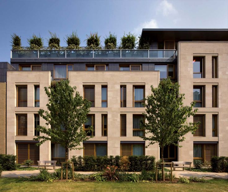 an apartment building with several balconies and trees on the top of it's roof