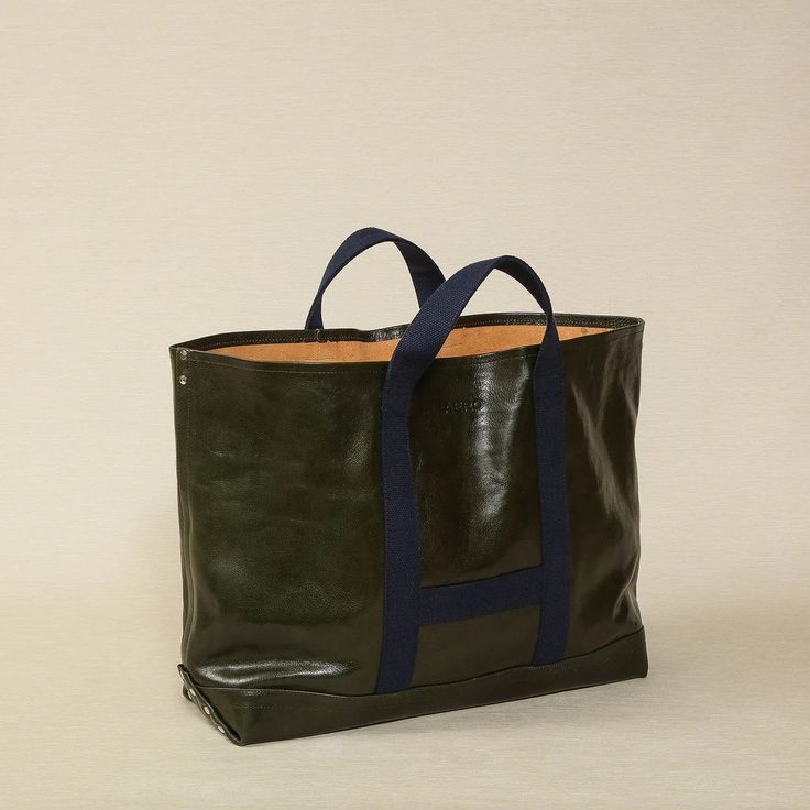 Aero leather utility bag in deep sage green glace leather with blue webbing handles 19" W x 7.5" D x 15.5" H Made in the USA. tote, tote bag, leather tote bag, leather bag, utility bag, leather utility bag Deep Sage Green, Pantry Gifts, Gourmet Catering, Copper Beech, Green With Blue, Utility Bag, Utility Tote, Tote Bag Leather, Leather Tote Bag