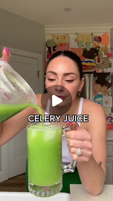 a woman holding a green drink in her hand and pouring it into a glass with the words celery juice