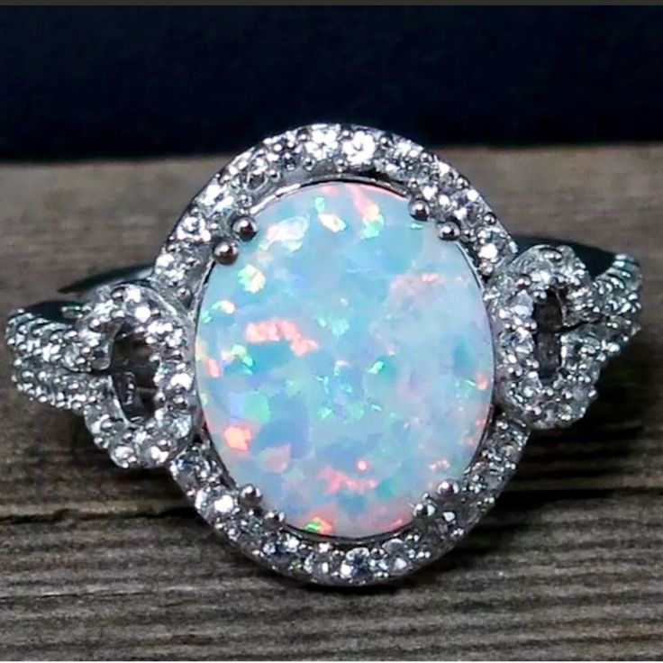 Carat Weight: 5.00 Cts Condition: Nwot Type: Oval Cut Opal, Lab Created Color: Flashes Of Multiple Colors Accent Stones: Swarovski Accent Carat Weight: .50 Cts Shapes: Round Clarity: Vvs Tcw: 5.50 Cts North To South: 15.5mm Ht Above Finger: 6.2mm Shank Width : 2.5mm Ring Size: 7 Gram Weight: 5 Grams Material Sterling: 925 Sterling Silver Hallmark: 925 *Retail Value: $499 Silver Halo Ring, Australian Opal Ring, Opal White, Opal Ring, Australian Opal, Halo Ring, White Topaz, Opal Rings, Druzy Ring