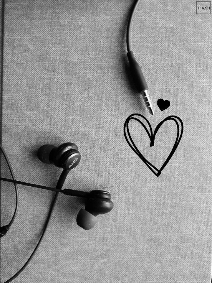 black and white photograph of headphones with hearts drawn on the wall next to them