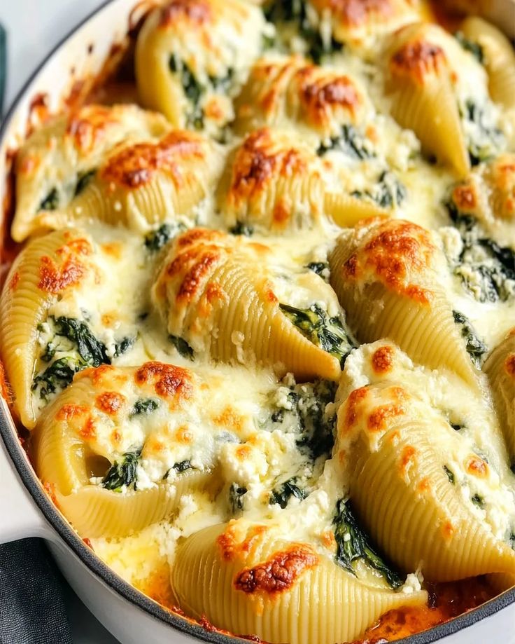 a casserole dish filled with pasta and spinach