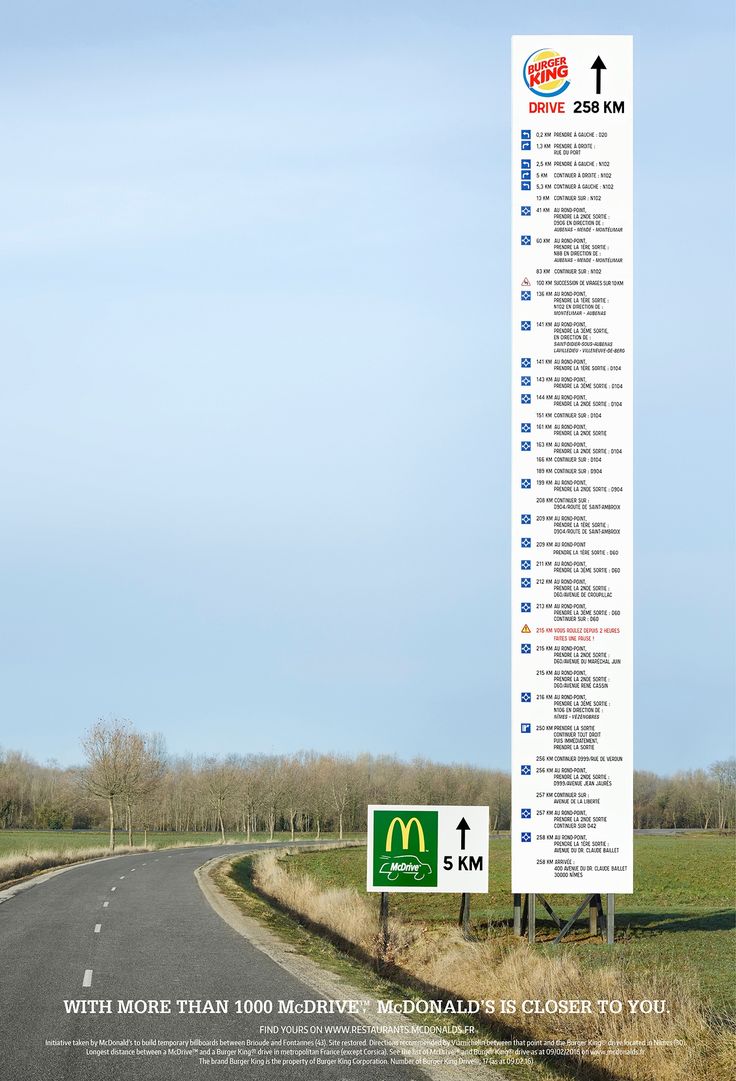 an advertisement for mcdonald's is shown on the side of a road in front of a field