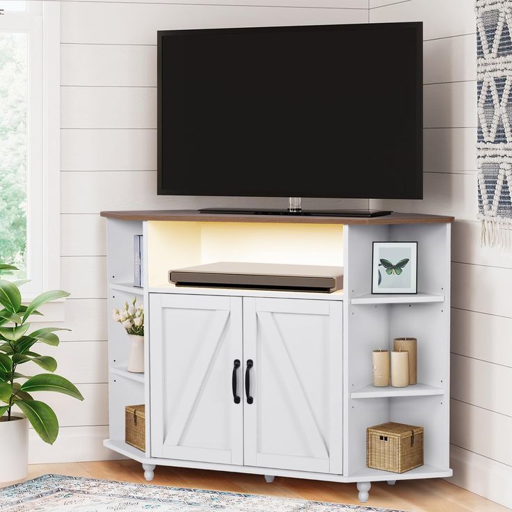 a flat screen tv sitting on top of a white cabinet